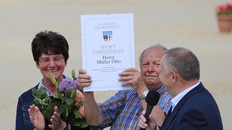 Landrat Thomas Bold (rechts) verlieh den Sport-Ehrenbrief des Landkreises an Otto Müller  vom Reiterhof Rhön (Mitte). Blumen gab es für Ehefrau Irma Müller. Foto: Sebastian Schmitt