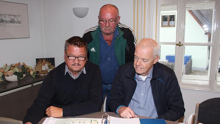 Die Entscheidung wird nicht leicht: Über den Plänen zerbrechen sich Bürgermeister Stefan Himpel, Pfarrer Andreas Sauer (rechts) und Dritter Bürgermeister Johann Höps die Köpfe.  Evi Seeger