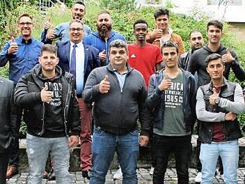 Das Bild zeigt (erste Reihe, von rechts) Schulleiter Hans-J&uuml;rgen Lichy, f&uuml;nf Auszubildende, stellvertretenden Gesch&auml;ftsf&uuml;hrer IHK zu Coburg Bj&ouml;rn Cukrowski sowie (zweite Reihe, von links) Leiter Berufliche Bildung IHK zu Coburg Rainer Kissing, Fachbetreuer f&uuml;r Sozialkunde-Berufsintegration Manfred Loch, Fachbetreuer f&uuml;r Wirtschaftswissenschaften Rainer Sagasser, Ausbildungsakquisiteur IHK zu Coburg Merouane Qsiyer, f&uuml;nf Auszubildende und Klassenleiterin Oberstudienr&auml;tin Katrin Gloss. Foto: IH...