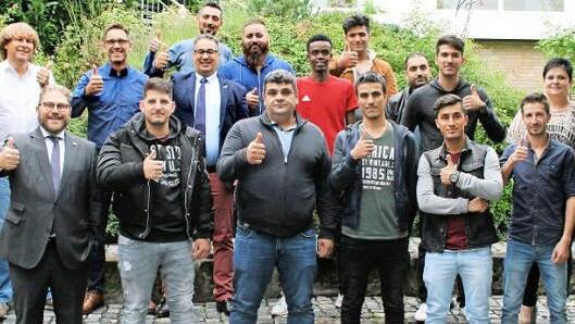 Das Bild zeigt (erste Reihe, von rechts) Schulleiter Hans-J&uuml;rgen Lichy, f&uuml;nf Auszubildende, stellvertretenden Gesch&auml;ftsf&uuml;hrer IHK zu Coburg Bj&ouml;rn Cukrowski sowie (zweite Reihe, von links) Leiter Berufliche Bildung IHK zu Coburg Rainer Kissing, Fachbetreuer f&uuml;r Sozialkunde-Berufsintegration Manfred Loch, Fachbetreuer f&uuml;r Wirtschaftswissenschaften Rainer Sagasser, Ausbildungsakquisiteur IHK zu Coburg Merouane Qsiyer, f&uuml;nf Auszubildende und Klassenleiterin Oberstudienr&auml;tin Katrin Gloss. Foto: IH...