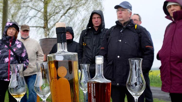 Bei einsetzendem Schneegestöber gab es Franziska Bischofs Informationsvortrag über den Rhöner Whisky am Dreimärker-Kreuz. Die Wanderer ließen sich nicht vom Besuch abhalten und erhielten zur Belohnung einen Schluck aus dem Probierglas. Foto: Gerd Schaar