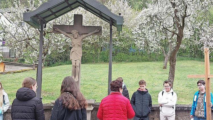 Firmlinge der Pfarreiengemeinschaft Saalekreuz Elfershausen sind an Bildstöcken vorbei den Kreuzweg gegangen und durften jeweils zu zweit das Holzkreuz ein Stück des Weges tragen.