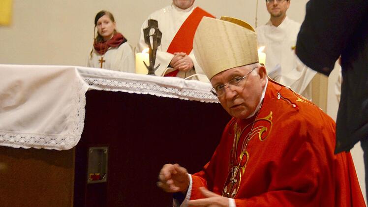 Die zentrale Handlung des Abends: Weihbischof Ulrich Boom hat soeben das Reliquienkästchen in der Kapsel des Altars platziert. Hier wartet er kurz darauf, die Platte überreicht zu bekommen, mit der er die Kapsel wieder verschließen kann. Foto: Kathrin Kupka-Hahn