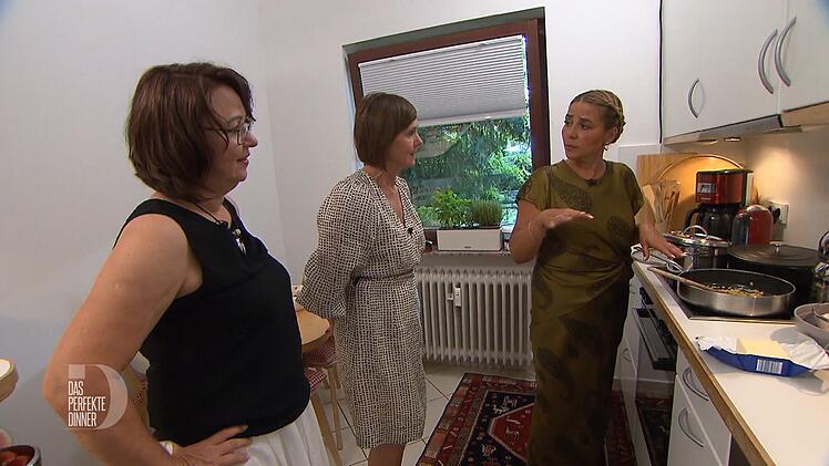 Ella (links) und Jasna (Mitte) lassen sich zeigen, wie man gebratenen Reis macht.
