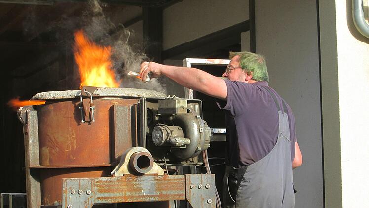 Peter Glasbrenner "füttert" den Schmelzofen mit Bronzestücken. Winfried Ehling