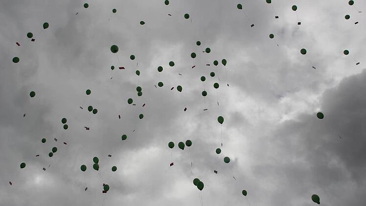 Die Luftballons fliegen davon.