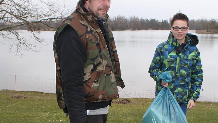 Ulli Merten und Robin Pittroff zeigen zwei Tüten voller Unrat - alles aus dem See gefischt. Foto: Sonja Adam
