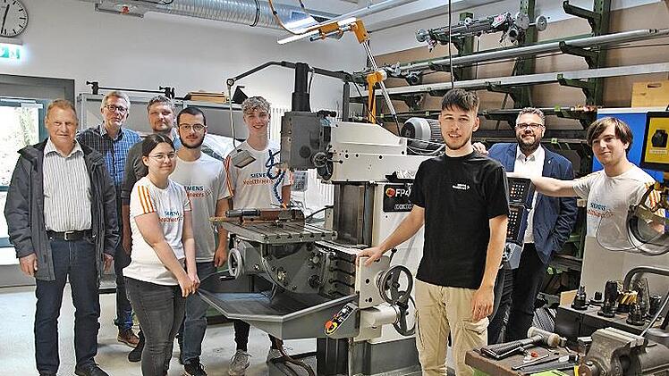 Übergabe einer Fräsmaschine: (hinten v. l.) Stefan Albrecht, Ausbildungscoach bei Siemens Healthineers, Robert Miemietz und Peter Pfann, Vorsitzende der Lebenshilfe, Marco Friepes (Zweiter v. r.), Ausbildungsleiter bei Siemens Healthineers und ein...