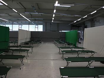 Der Schlafbereich für die alleinreisenden männlichen Flüchtlinge. Hinter der grauen Absperrung kommen die etwas kleineren Nischen für die Familien. Im vorderen Bereich der Halle ist ein Aufenthaltsraum eingerichtet. Rechts geht es zu den Sanitärcontainern.  Foto: Anja Greiner