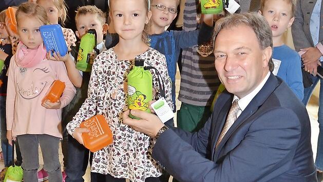 Mit gro&szlig;en Augen nahmen die Abc-Sch&uuml;tzen in der GS Wallenfels die "Emil-Flaschen" und Brotzeitdosen, hier aus H&auml;nden von Landrat Klaus L&ouml;ffler, entgegen. Foto: Karl-Heinz Hofmann