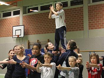 Er hat die beste Aussicht: der neunjährige Gabriel (oben). Vorne Cara, Luna, Richard, Elena und Leon, ebenfalls in James-Bond-Pose, dahinter die Trainerinnen Sabine und Heidi Diener, die Gabriel in lichte Höhen heben. Foto: Gerd Ludwig