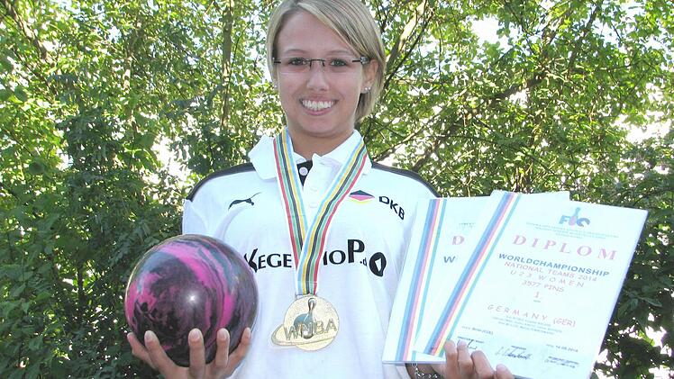 Stolz zeigt Janine Wehner ihre Goldmedaille, die das deutsche Team mit Weltrekord holte, und ihre WM-Urkunden.