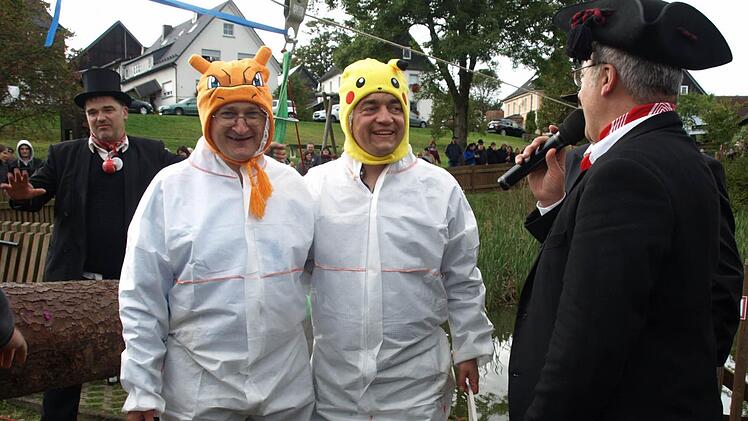 Nach dem Wettkampf wird gemessen und gezählt, wer mehr Wasserbomben im Eimer versenken konnte. Glurak (Pater Jan, li) oder Pikachu (Jens Korn, Mitte), rechts "Jack" Roland Schmidt, der "Frankenwald-Gottschalk".Foto: Susanne Deuerling