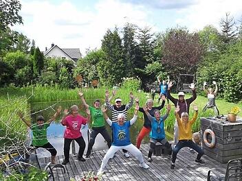 Spaß bei Yoga am Teich vermittelt Yogacoach Birgit Schmitt (vorne links) mit ihren leichten Übungen, die am frühen Morgen die Lebensgeister wecken.  Foto: K.- H. Hofmann