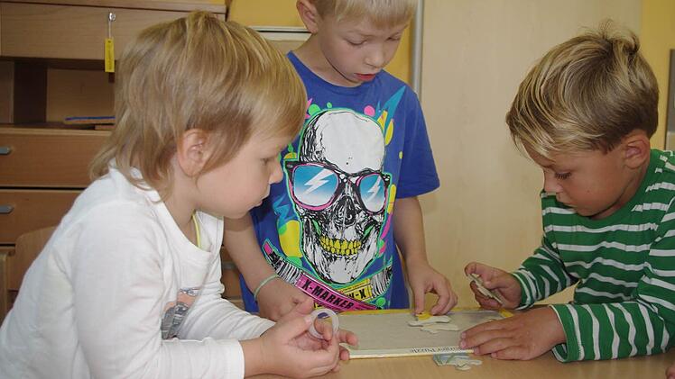 Arthur, Aaron und Luca (von links) haben Spaß beim Puzzeln.