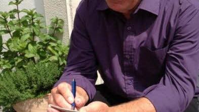 Reinhard Kube rechnet bei seiner Kellnertätigkeit mit Block und Stift Foto: Corinna Igler