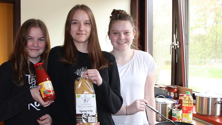 Kristina Brauer, Milena Brust und Celine Keßler in der Schulküche: Sie haben versucht, Spaghetti und Tomatensoße regional, ökologisch, fair und plastikfrei zu bekommen - und dafür nur fünf Euro auszugeben. Foto: Ulrike Müller