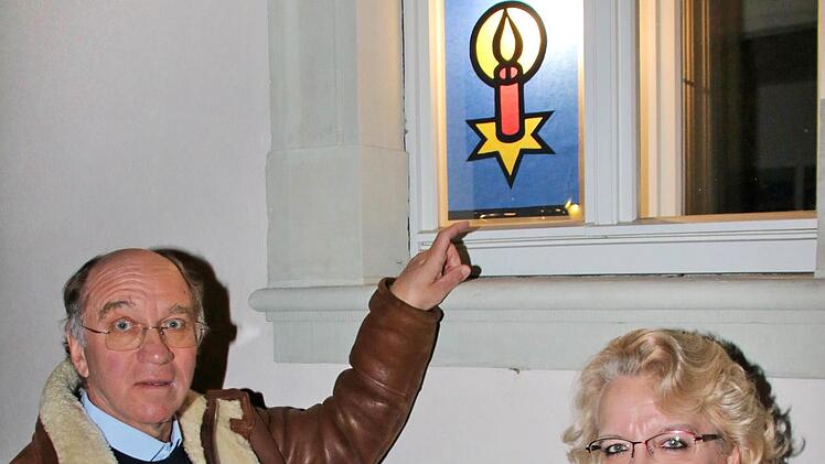 Der Adventskalender in den Fenstern des Heimatsspielhauses wurde von der  Klasse 7b der Mittelschule unter der Leitung von Lehrerin Petra Georg  (rechts) gestaltet. Links der Vorsitzende des Heimatspielhaus-Vereins,  Martin Kuchler. Foto: Dieter Britz