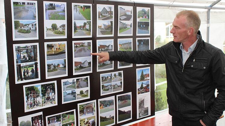 Ortssprecher Stefan Kormann blickt anhand einer Schautafel mit Bildern auf den Verlauf der Dorferneuerung zurück.