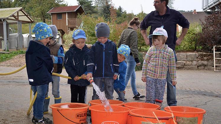 Wasser marsch 1: Die Kinder dürfen auch für ausreichend Wasser sorgen und füllen mit dem Schlauch sechs Eimer voll.  Foto: Kathrin Kupka-Hahn