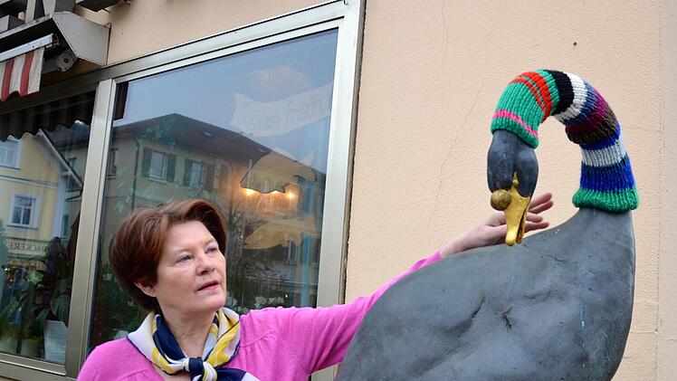Helga Dotterweich freut sich über die wollene Deko am Schwan vor ihrem Haus.  Foto: Wilfried Roppelt