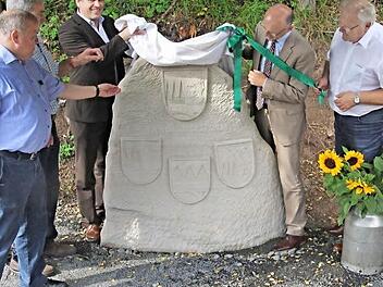 Der Gedenkstein, der an die ehemaligen Landkreise Ebern, Haßfurt und Hofheim erinnert, wurde von (von links) Bürgermeister Karl-Heinz Kandler aus Kirchlauter, OGV-Vorsitzenden Horst Hornung, MdL Steffen Vogel, Landrat Wilhelm Schneider und Bürgermeister Claus Bittenbrünn aus Königsberg enthüllt. Die Infotafel rechts erläutert die Historie.  Fotos: Helmut Will