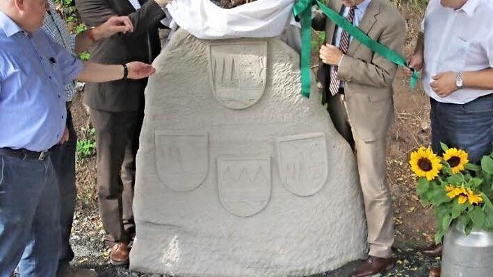 Der Gedenkstein, der an die ehemaligen Landkreise Ebern, Haßfurt und Hofheim erinnert, wurde von (von links) Bürgermeister Karl-Heinz Kandler aus Kirchlauter, OGV-Vorsitzenden Horst Hornung, MdL Steffen Vogel, Landrat Wilhelm Schneider und Bürgermeister Claus Bittenbrünn aus Königsberg enthüllt. Die Infotafel rechts erläutert die Historie.  Fotos: Helmut Will
