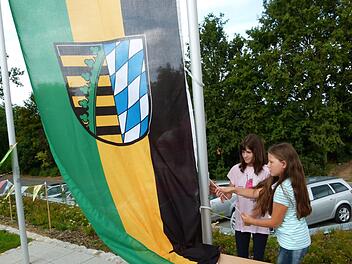 Schüler hissen zum ersten Mal eine von mehreren Fahnen. Foto: Doris Weidner
