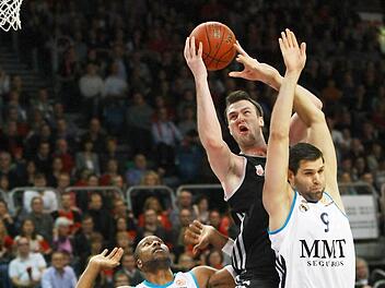 Obwohl er von Felipe Reyes (r.) und Marcus Slaughter (l.) bedr&auml;ngt wird, kann sich der Bamberger Center A.J. Ogilvy den Ball sichern.Fotos: sportpress