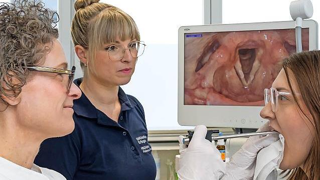 Anne Sch&uuml;tzenberger (l.), Leiterin der Fachabteilung Phoniatrie und P&auml;daudiologie der HNO-Klinik des Uniklinikums Erlangen, untersucht mittels Videostroboskopie die Stimmlippenschwingung einer Patientin.