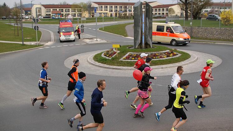 Die Pace-Makerin mit dem Luftballon, auf dem die Zielzeit von 4:00 Stunden steht, l&auml;uft mit einer Gruppe durch den Kreisel an der Staffelsteiner Kurklinik. Foto: Mario Deller