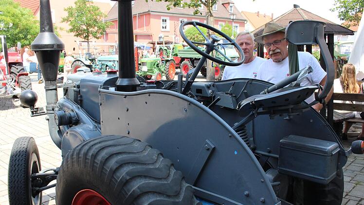 Reinhold Göring, Vorsitzender der Bulldogfreunde Mühlhausen (rechts) und Friedrich Zürl bewundern den ältesten Lanz-Schlepper, Baujahr 1939 mit einer Zulassung aus dem Kreis Neustadt/Aisch. Foto: Evi Seeger