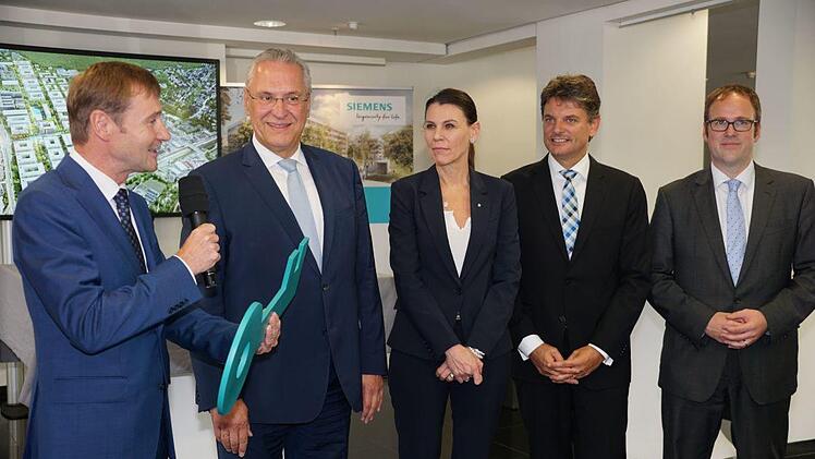 Schlüsselübergabe: Klaus Helmrich, Mitglied des Vorstands der Siemens AG, Innenminister Joachim Herrmann, Ministerin für Wissenschaft und Kunst, Prof. Dr. med. Marion Kiechle, Prof. Dr. Joachim Hornegger, Präsident der FAU, OB Dr. Florian Janik (v. l.)    Foto: Pascale Ferry