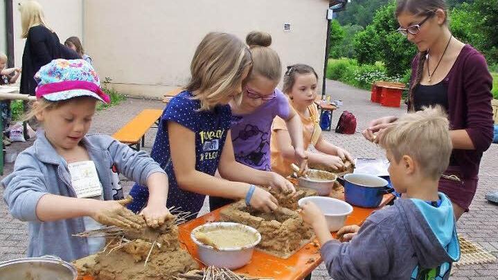 Alina, Pauline, Lena, Alina, Helferin Franka und Konstantin bauen Lehmhütten.  Foto: Heike Schülein