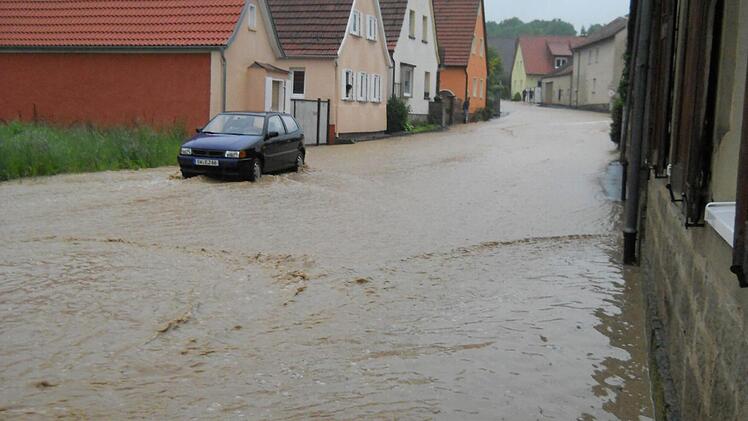 Früh morgens hatte das Wasser die Straße in Poppenlauer in einen Fluss verwandelt. Foto: Diana Hochrein