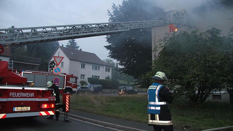 Mit der Drehleiter wird eine Frau aus dem brennenden Haus geholt, die andere kann noch selbstständig über das Treppenhaus herausgeholt werden.
