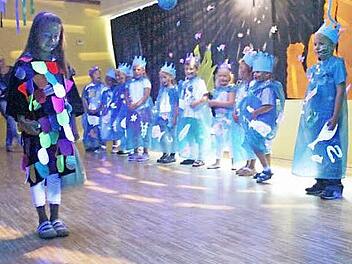 Szene aus dem Musical "Regenbogenfisch" mit (von links) Larissa, Maria, Mia-Laureen, Mariella, Emily, Leonie, Fabian, Lena, Mia, Raphael, Felix und dem Regenbogenfisch Jule (vorne links) Foto: Hofmann