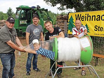 Hier k&ouml;nnen Eltern ihre Kinder kostenlos einpacken und mitnehmen, stand auf dem Plakat. Etliche Eltern h&auml;tten vermutlich davon gerne Gebrauch gemacht. Im Bild von links die Besitzer der Christbaumkulturen Dieter Rippel, Christian Be&szlig;ler, Michael Be&szlig;ler und Paul Hennemann, der die B&auml;ume an den Mann bringt. Im Netz der 6-j&auml;hrige Max  Fotos: Evi Seeger