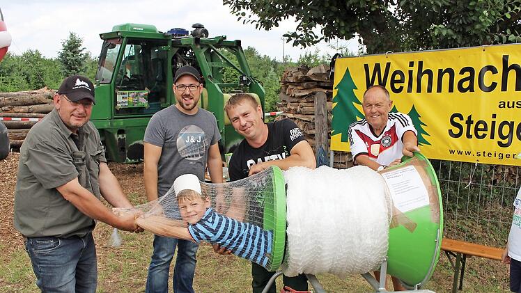 Hier k&ouml;nnen Eltern ihre Kinder kostenlos einpacken und mitnehmen, stand auf dem Plakat. Etliche Eltern h&auml;tten vermutlich davon gerne Gebrauch gemacht. Im Bild von links die Besitzer der Christbaumkulturen Dieter Rippel, Christian Be&szlig;ler, Michael Be&szlig;ler und Paul Hennemann, der die B&auml;ume an den Mann bringt. Im Netz der 6-j&auml;hrige Max  Fotos: Evi Seeger