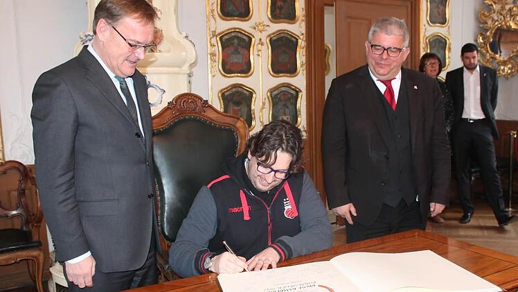 Unmittelbar nach dem Friseur-Termin in Ebern zum Bamberger Oberbürgermeister: Andrea Trinchieri beim Eintrag ins goldene Buch der Stadt Bamberg; Andreas Starke schaut dem Coach des Pokalsiegers über die Schulter auf die Finger. Um eine Vertragsverlängerung ging's ja nicht. Foto: Brose Bamberg