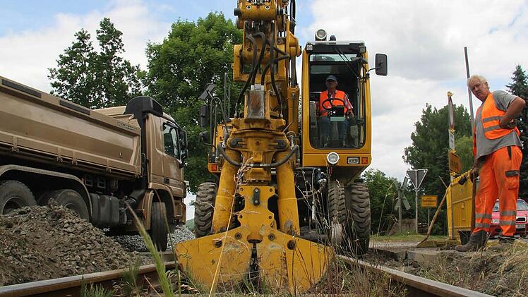 Mit dem Spezial-Zweiwege-Bagger, der auch auf Schienen fahren kann, werden die Holzschwellen herausgenommen.