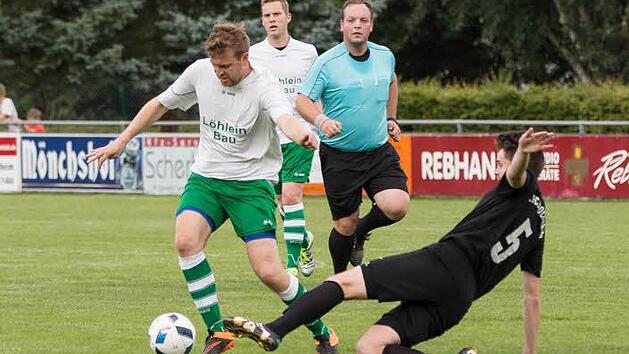 FC Stockheim - SV Friesen II: FC-Akteur Oliver Schubart (schwarzes Trikot) kann mit einer Gr&auml;tsche den Lauf von G&auml;steangreifer Dominic Kraus stoppen.  Foto: Heinrich Wei&szlig;