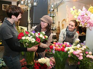 Sylvia Lechner (Lechner Floristik, Höchstadt) mit Kundschaft und einem Arm voller Frühling, rechts Floristikgesellin Christina Pfannenmüller