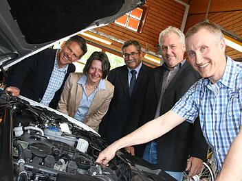 Lehrer Peter Dacho (rechts) begutachtet den Motor des neuen Hybridautos mit (von links) Thomas Mahlmeister vom Audi-Autohaus, Schulleiterin Karin Maywald, Gerd Schießer vom Versorgungswerk der Innungen und Fachbetreuer Achim Herkert. Fotos: Ralf Ruppert