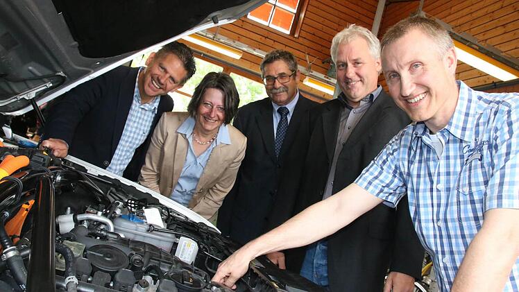 Lehrer Peter Dacho (rechts) begutachtet den Motor des neuen Hybridautos mit (von links) Thomas Mahlmeister vom Audi-Autohaus, Schulleiterin Karin Maywald, Gerd Schießer vom Versorgungswerk der Innungen und Fachbetreuer Achim Herkert. Fotos: Ralf Ruppert