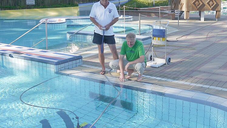 Eine Aufgabe für schattige Stunden: Bademeister Bernd Steckmann (links) erklärt Berthold Köhler, was er und seine Kollegen alles zu tun haben, bevor die Badegäste kommen - zum Beispiel das Spaßbecken für Kinder zu reinigen. Foto: privat