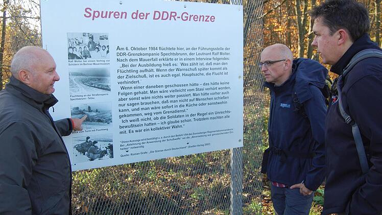 Der Tettauer Bürgermeister Peter Ebertsch (links) zeigt den wandernden Redakteuren Oliver Schmidt (Mitte) und Thomas Apfel eine Informationstafel an der ehemaligen deutsch-deutschen Grenze. Foto: Detlef König