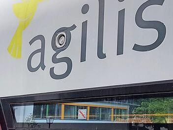 Haltstation in Ebern für den agilis-Zug. Im Fenster spiegelt sich das moderne Gebäude der Grundschul-Mensa. Foto: Eckehard Kiesewetter