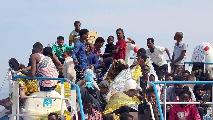 Flüchtlinge sitzen am Karsamstag an Bord des Schiffes "Iuventa" der Nichtregierungsorganisation "Iuventa Jugend rettet", die sich etwa 20 Meilen vor der Küste von Libyen aufhält. Vor der afrikanischen Küste befindet sich auch das Schiff Sea-Eye. Innerhalb von 48 Stunden haben private Hilfsorganisationen auf dem Mittelmeer mehrere Tausend Menschen in Seenot gerettet. Inzwischen ist die "Iuventa" selbst in Seenot geraten und komplett manövrierunfähig, weil so viele Personen an Bord sind. Siehe ...