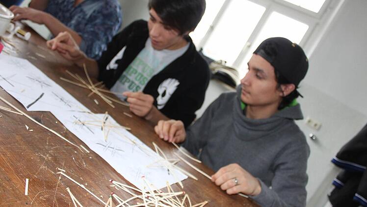 Reza und Sami (v. l.) beim Sterneflechten. Sie sind zwei von 19 jungen Flüchtlingen, die in der Lichtenfelser Berufsschule unterrichtet werden und sich auch an einer Hilfsaktion beteiligen. Foto: Popp